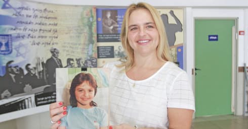 גנון כיום עם תמונתה כתלמידה בבית הספר | צילום: אסף פרידמן