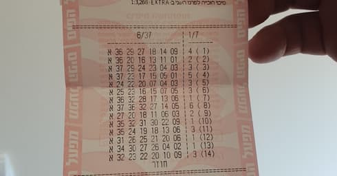 הזוכה מחזיק את טופס הזכייה ב- 9.3 מיליון שקל (צילום: אבי חיים)