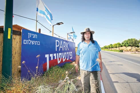 עמי פינשטיין ושלט המריבה. "יש פה מלחמה כלכלית" | צילום: אבי מועלם עמי פינשטיין ושלט המריבה. "יש פה מלחמה כלכלית" | צילום: אבי מועלם