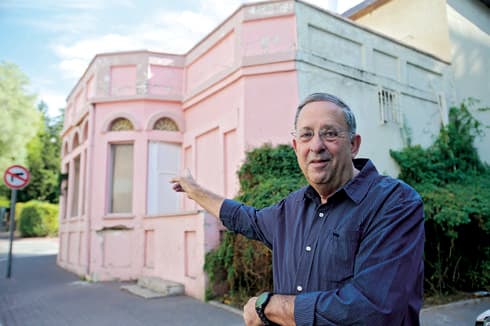ישראל פרקר על רקע אחד המבנים לשימור | צילום: אבי מועלם