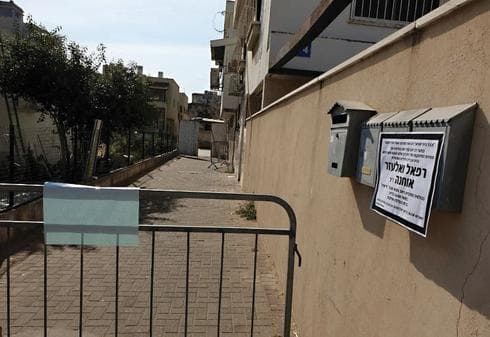 מודעת האבל על הבית השרוף. כביסה מפויחת ליד הדלת | צילום: דנה קופל