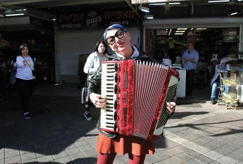 אומנית רחוב. ציירים, נגנים וזמרים בין דוכני הפירות | צילום: אסף פרידמן