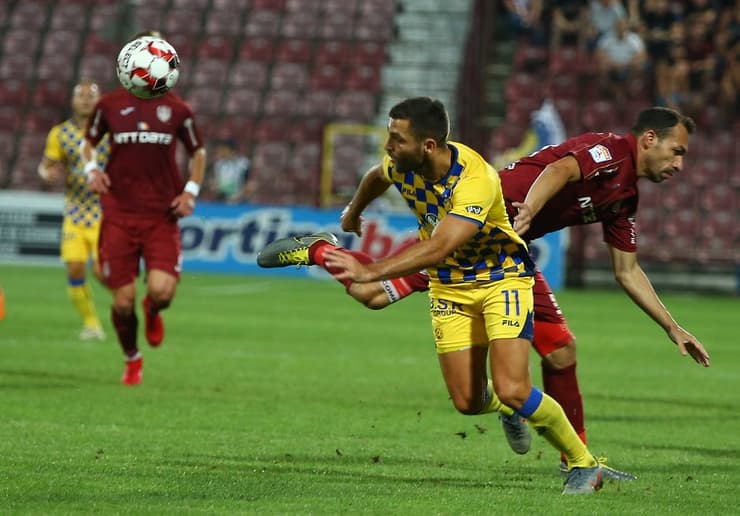 Itay Shechter en plena lucha con un defensor del equipo rumano. Maccabi Tel Aviv perdió en el partido de ida y deberá ganar la revancha en Israel para mantener su ilusión europea 