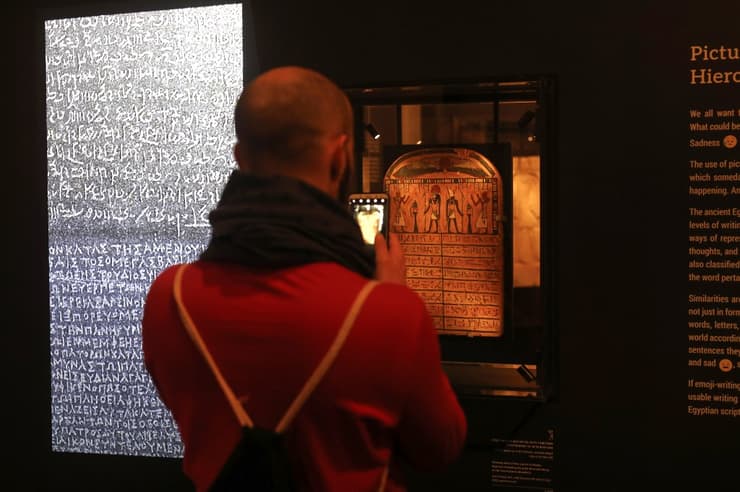 Un visitante toma una fotografía de los antiguos jeroglíficos en la exposición en Jerusalem (AFP) Exhibición