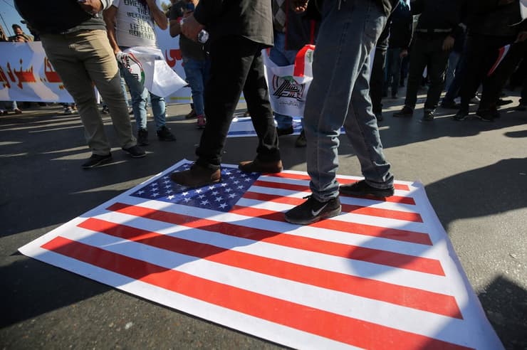 Manifestantes pisan la bandera estadounidense