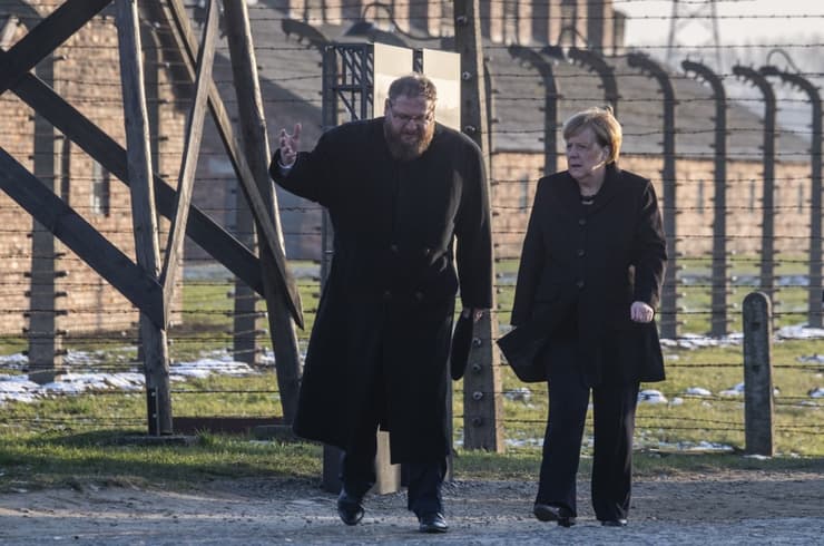 Piotr Cywiński junto a la canciller alemana, Angela Merkel, durante su visita a Auschwitz en diciembre de 2019 (AFP) Piotr Cywiński junto a la canciller alemena, Angela Markel