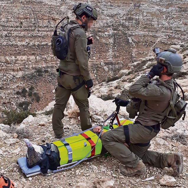 Guy y su compañero Yochai tratan a un hombre herido en el desierto de Judea poco antes de que fueran llamados al desastre de Tsafit (Cortesía) Guy y su compañero Yochai tratan a un hombre herido en el desierto de Judea poco antes de que fueran llamados al desastre de Tsafit