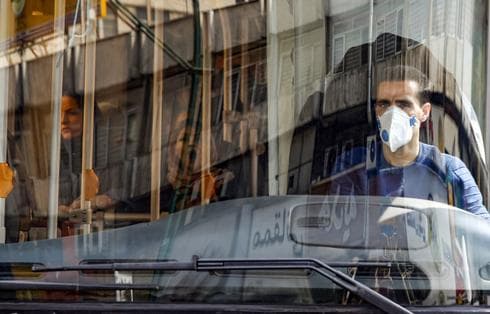 Un conductor de bus iraní, con mascarilla quirúrgica