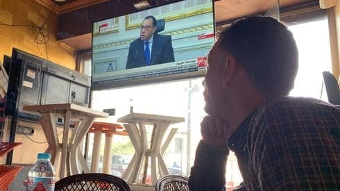Hombre egipcio observa al primer ministro anunciando medidas para contrarrestar el coronavirus. (Reuters) Hombre egipcio observa al primer ministro anunciando medidas para contrarrestar el coronavirus.