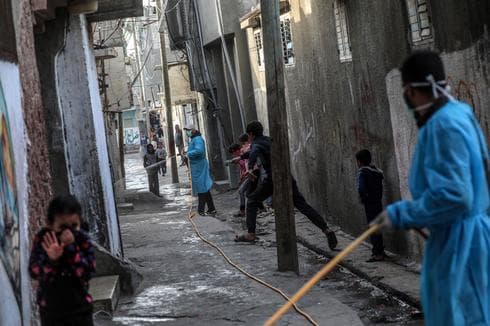 Trabajadores desinfectan un campo de refugiados en el centro de la Franja de Gaza. (EPA) Trabajadores desinfectan un campo de refugiados en el centro de la Franja de Gaza.