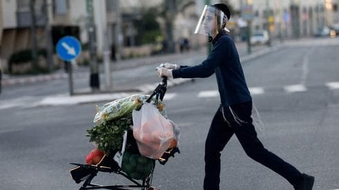 Un residente de la ciudad haciendo las compras y protegido contra COVID-19. 
