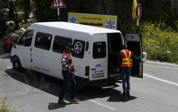 Con mascarillas y chaleco amarillo, los voluntarios palestinos controlan la entrada a las aldeas de Judea y Samaria. 