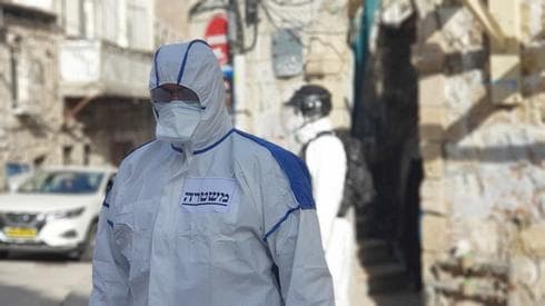 Oficial de policía en la protección de los equipos de cumplimiento de orden de distanciamiento social en el barrio ultra ortodoxo de Mea Shearim de Jerusalem. (Gentileza Policía de Israel) salud coronavirus