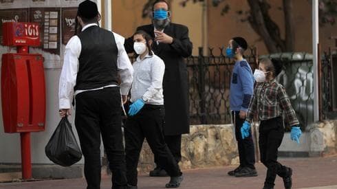 Niños pequeños junto a su padre en Bnei Brak, durante la pandemia de coronavirus. (AFP) Niños pequeños junto a su padre en Bnei Brak