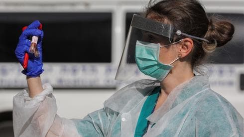 Una trabajadora de la salud del Centro Médico Hadassah en Jerusalén manipula muestras de test de coronavirus. (Olivier Fitoussi/Flash90) Una trabajadora de la salud del Centro Médico Hadassah en Jerusalén manipula muestras de test de coronavirus.
