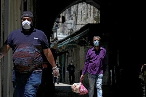 Palestinos con mascarillas en la Ciudad Vieja de Jerusalem 