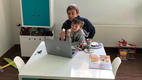 Pésaj en casa. Un niño y su padre, de la comunidad judía de Chile, comparten la celebración de forma digital. 