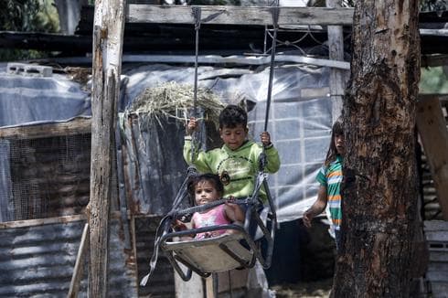 Niños palestinos juegan en un columpio cerca de su casa, al este de la ciudad de Gaza. (AFP) Niños palestinos viajan en un columpio cerca de su casa, al este de la ciudad de Gaza.