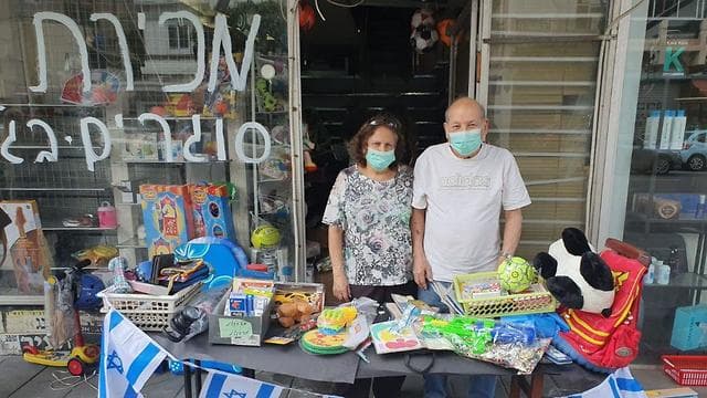Una pareja en Tel Aviv cierra su comercio debido a la crisis del coronavirus.