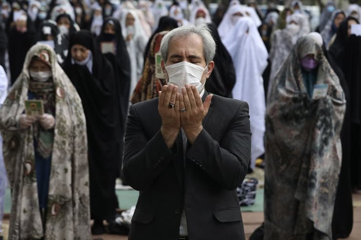Personas rezan fuera de una mezquita en Irán.