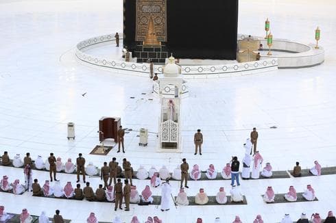 Fuerzas de seguridad se ubican entre los pocos fieles que rezan frente la Kaaba en la Gran Mezquita de la ciudad de La Meca, en Arabia Saudita. (AP) Fuerzas de seguridad se ubican entre los fieles que se rezan frente la Kaaba en la Gran Mezquita de la ciudad de La Meca, en Arabia Saudita.
