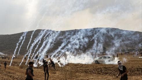 El gas lacrimógeno lanzado por las tropas de las FDI cae entre los palestinos que protestan por la construcción de un puesto avanzado cerca del asentamiento de Shiloh en Judea y Samaria, 17 de octubre de 2019. 