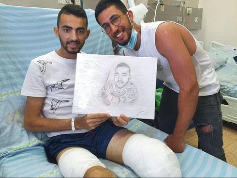 Shadi Ibrahim sosteniendo un dibujo de él mismo.