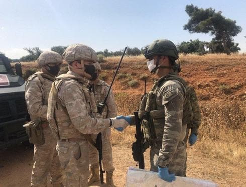 Un soldado ruso y uno turco estrechan sus manos durante una patrulla conjunta en Siria. (AFP) Un soldado ruso y uno turco estrechan sus manos durante una patrulla conjunta en Siria.