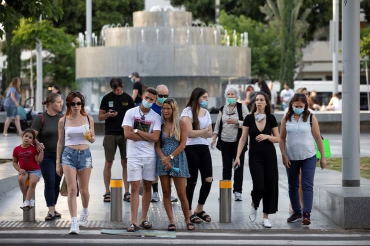 Los peatones, algunos con máscaras, se preparan para cruzar la calle en el Círculo Dizengoff de Tel Aviv. (Reuters) Los peatones, algunos con máscaras, se preparan para cruzar la calle en el Círculo Dizengoff de Tel Aviv.