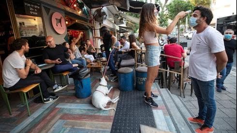 A un cliente le toman la temperatura en la entrada de un restaurante de Tel Aviv. (Reuters) A un cliente le toman la temperatura en la entrada de un restaurante de Tel Aviv.