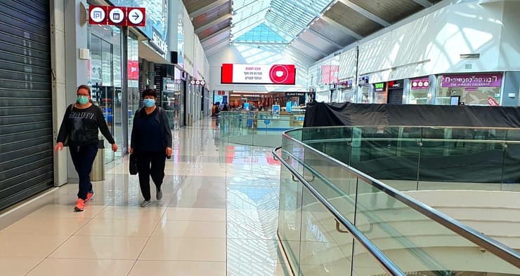 Compradores utilizan mascarillas en un centro comercial de Rehovot 