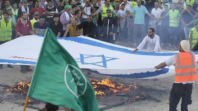 Partidarios de los Hermanos Musulmanes prenden fuego una bandera de Israel en Jordania durante la operación 'Margen Protector' de las FDI en Gaza en 2014. (AFP) Partidarios de los Hermanos Musulmanes incendian prenden fuego una bandera de Israel en Jordania durante la operación 'Margen Protector' de las FDI en Gaza.
