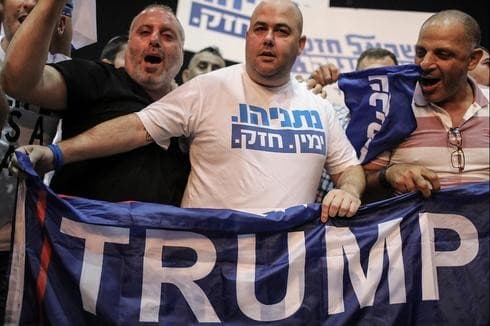 Simpatizantes del Likud sostienen una bandera de apoyo a Trump.