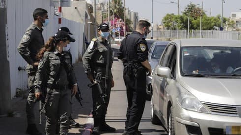 Los oficiales de policía imponen un cierre en Lod para frenar la propagación del virus en la ciudad. (AFP) Los oficiales de policía imponen un cierre en Lod para frenar la propagación del virus en la ciudad.