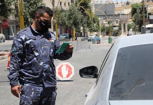 Un miembro de las fuerzas de seguridad palestinas controla los automóviles que ingresan a la ciudad cisjordana de Hebrón. (AFP) Un miembro de las fuerzas de seguridad palestinas controla los automóviles que ingresan a la ciudad cisjordana de Hebrón.