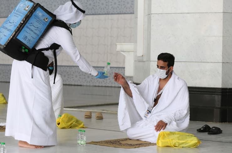 Un peregrino musulmán recibe agua en la Gran Mezquita de La Meca.