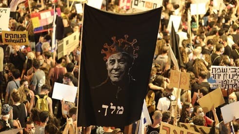 Un manifestante con un cartel que muestra a Benjamin Netanyahu con una corona con forma de coronavirus con la palabra 'rey' debajo durante una protesta en Jerusalem. (EPA) Protestas en Israel