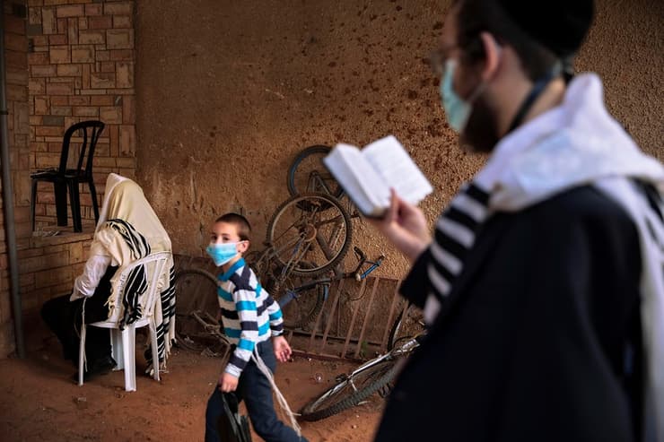 Judíos ultraortodoxos rezan afuera de una sinagoga en Bnei Brak. 