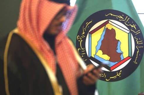 Un hombre frente al estandarte del Consejo de Cooperación del Golfo en Kuwait. 