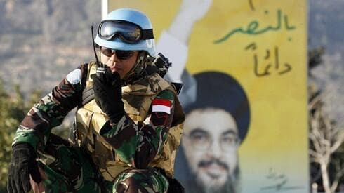 Un miembro de la FPNUL frente a un cartel del líder de Hezbollah Hassan Nasrallah en el sur del Líbano. (AFP) Un miembro de la FPNUL frente a un cartel del líder de Hezbolá Hassan Nasrallah en el sur del Líbano.