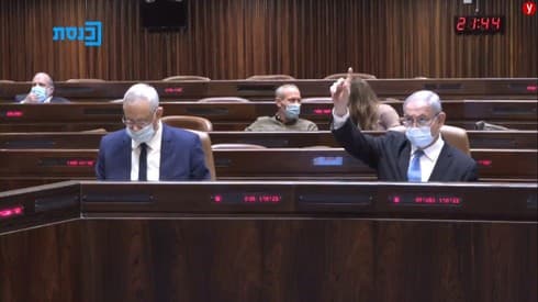 Gantz y Netanyahu a las 21.44, minutos antes de aprobar la ley que posterga el debate presupuestario. (Knesset TV) Gantz Netanyahu Knesset