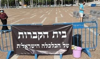 Texto en hebreo que dice: “el cementerio de la economía israelí”. 