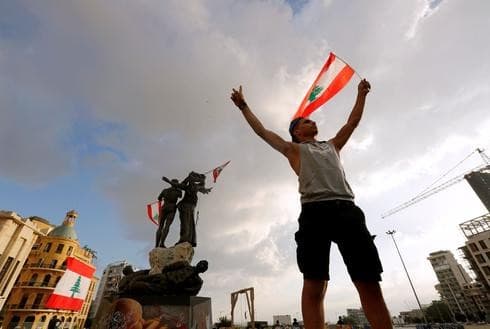 Un manifestante sostiene la bandera libanesa en la Plaza de los Mártires de Beirut. (Reuters) Un manifestante sostiene la bandera libanesa en la Plaza de los Mártires de Beirut.
