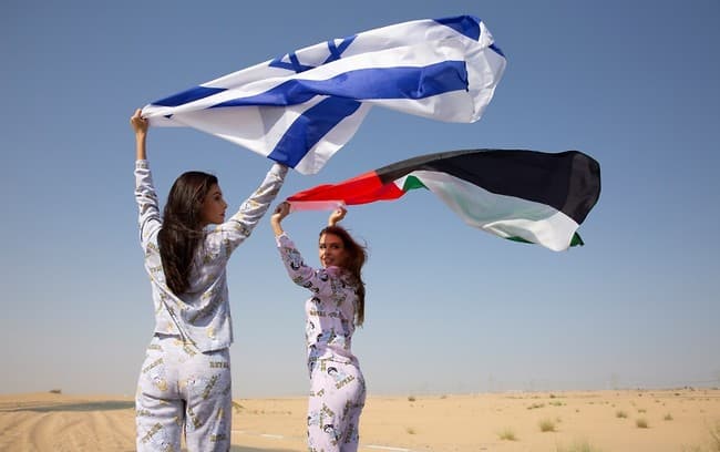Las modelos elevan las banderas de Israel y Emiratos.