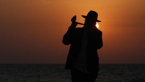 Un hombre ultraortodoxo toca el shofar en una playa de Tel Aviv durante el cierre general. (EPA) Un hombre ultraortodoxo toca el shofar en una playa de Tel Aviv durante el cierre general.