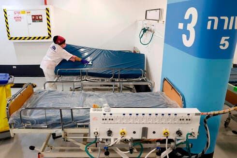 Una empleada del hospital Rambam prepara las camas para recibir a los pacientes en la nueva "ala covid" del hospital Rambam.