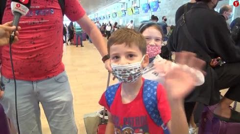 Con mascarilla y de vacaciones, familias israelíes escapan antes de que se endurezcan las pautas de salud. (Shmulik Davidpur) Aeropuerto Ben Gurion Niño