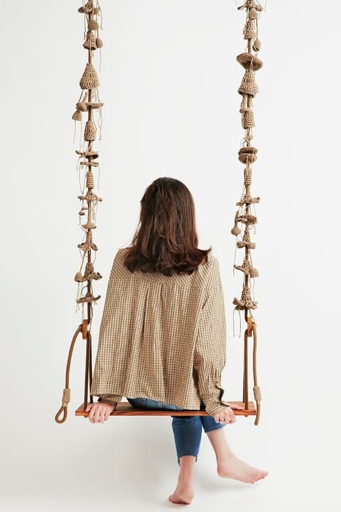 Un columpio de madera y tejido a crochet. 