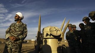 Un clérigo iraní junto a misiles y tropas del ejército durante ejercicios militares en un lugar no revelado en Irán.