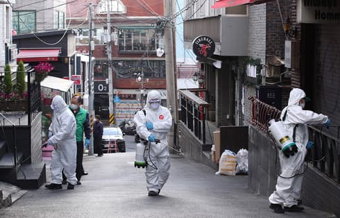 Trabajadores de la salud de Corea del Sur desinfectan una calle en Seúl. 